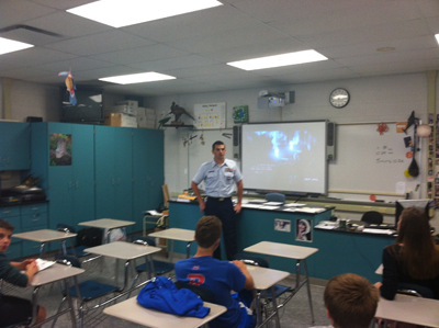 A coast guard recruiter speaks to students.