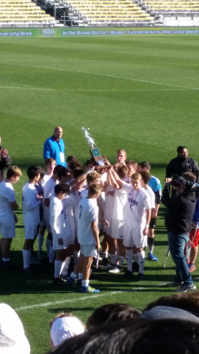 The team held up the state runner-up trophy after the game.