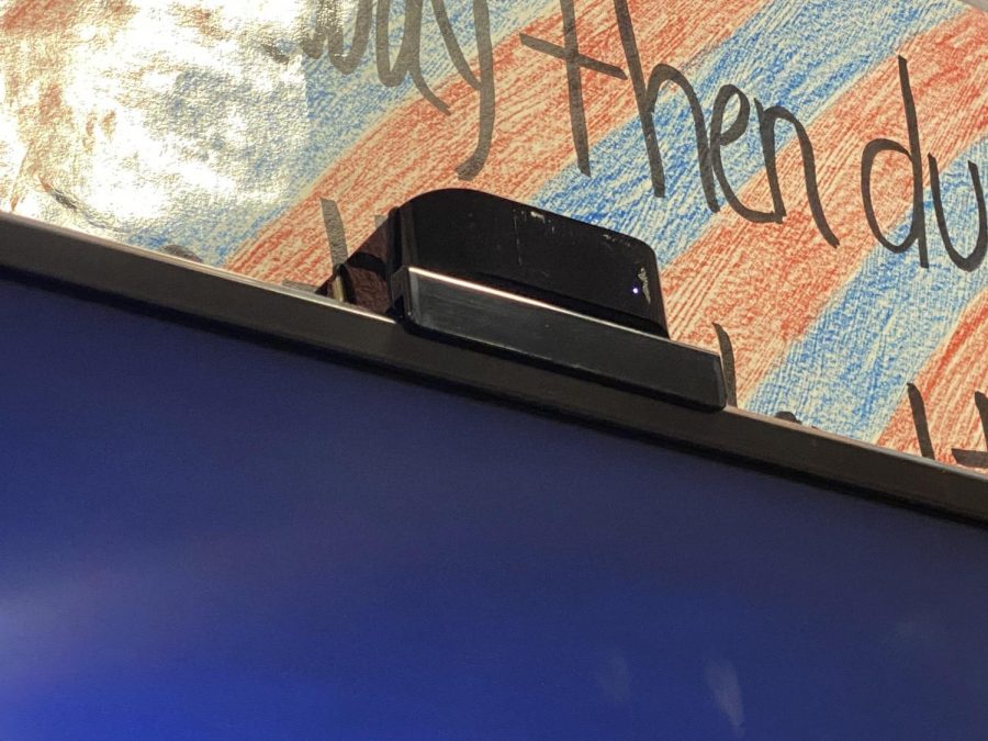 An Apple TV box sits upon a Smart TV.