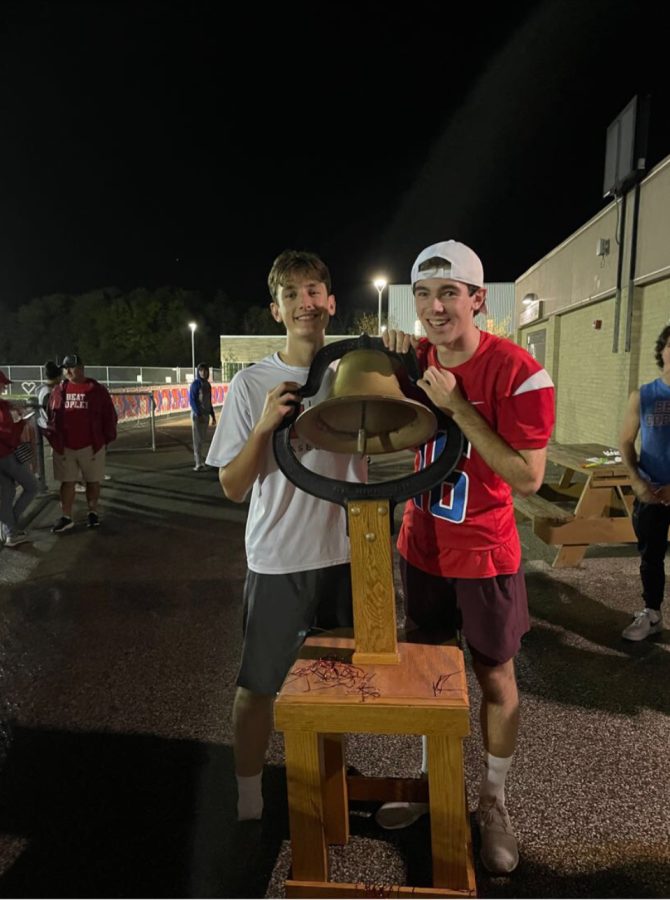 Ben and Sam Eberhardt pose with the victory bell after defeating Copley. 