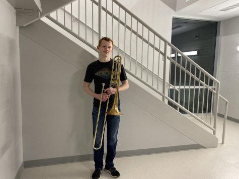 Johnson stands holding his trombone.