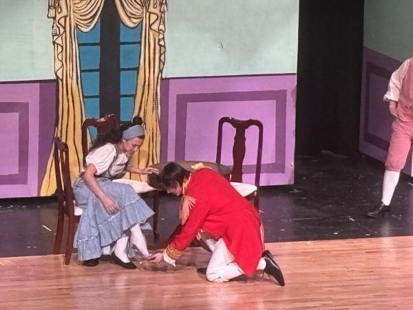 Prince Charming (Noah Restivo) fits Cinderella (Gianna Kosir) with her glass slipper.