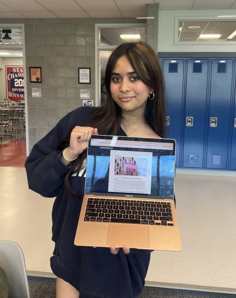 Yadavalli holds computer showing her most recent online article on platfrom, Conversatia. 