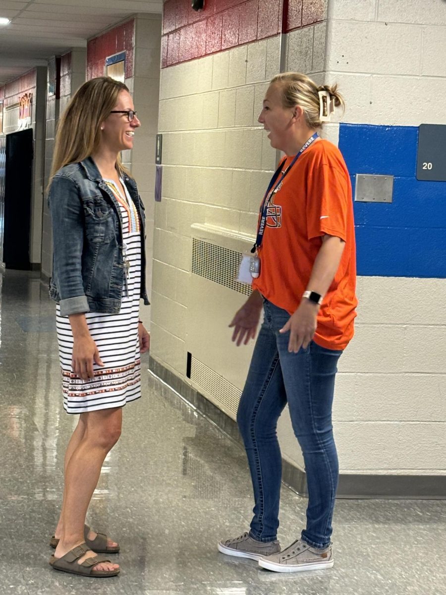 Kieser talks with teacher in the halls of Richfield Elementary School.