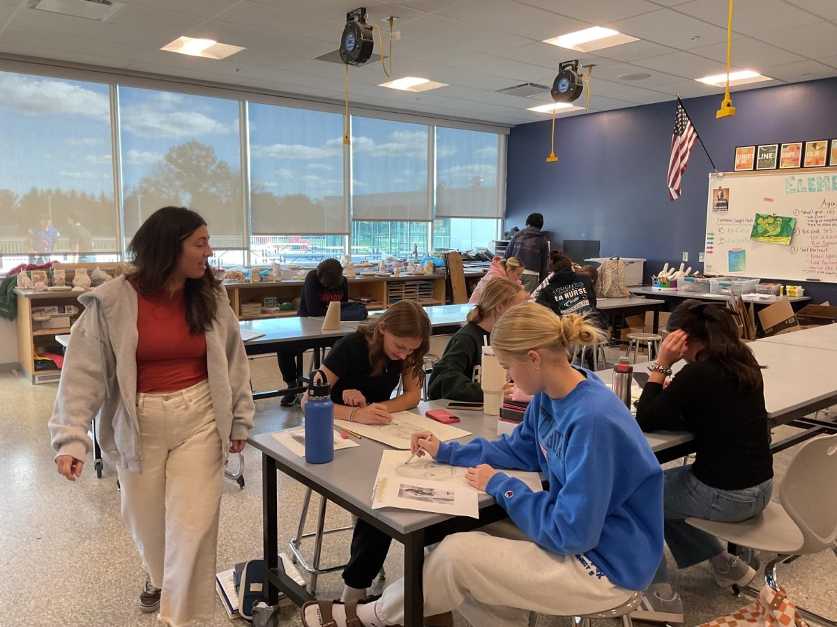 Art teacher and Art Club adviser Sarah Zustin helps students during class.