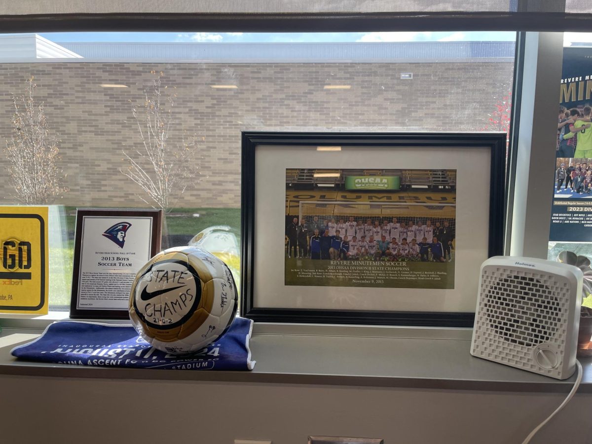 A photograph of the 2013 Boys Soccer Team, the induction award, and a soccer ball with players' signatures sit on display in Sandor Jakab's classroom.