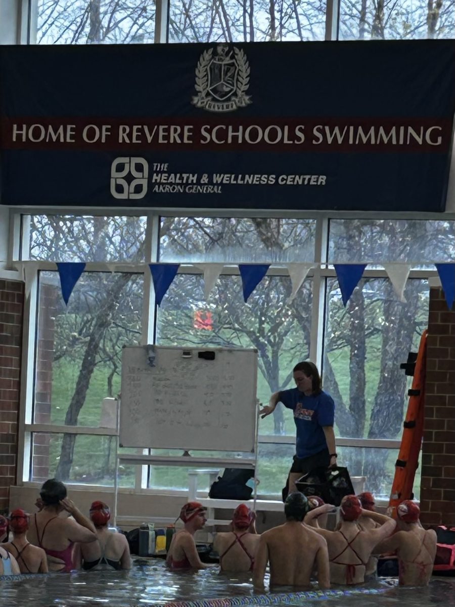 Swim team coach Annie Lochridge speaks to team about the practice warm up. 