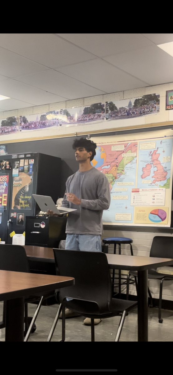 Chandran speaking in front of his fellow debaters. 