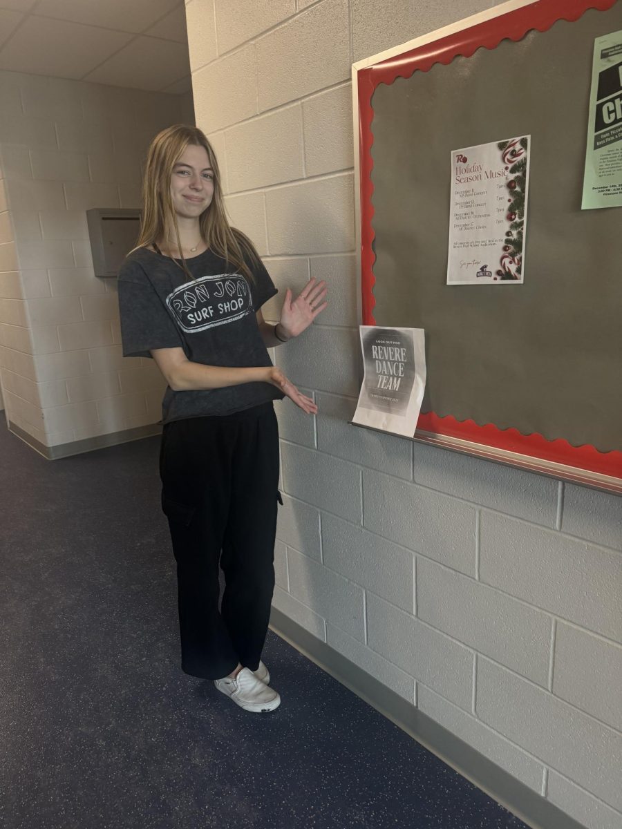 Pestonik stands with a poster she hung up to advertise the dance team. 