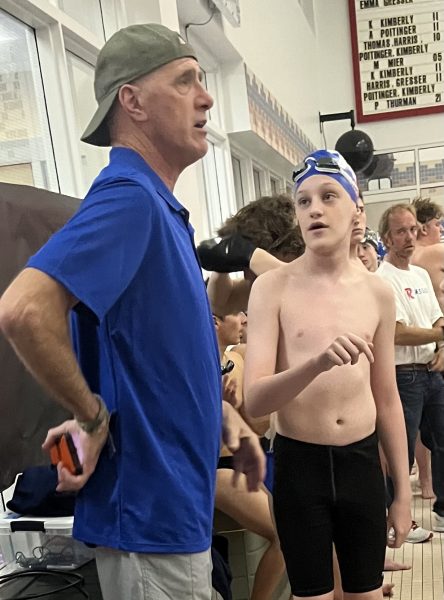 Russ Neubert coaching up a swimmer during the opening match of the season.