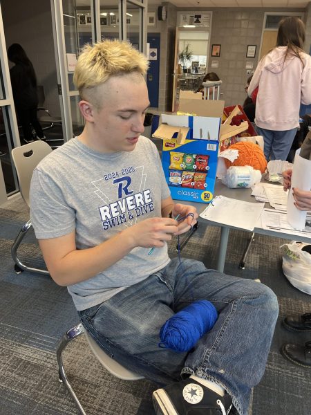 Senior member of Stitch Club knits at their first meeting. 