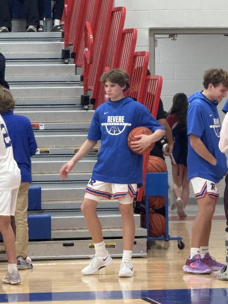 Rahas stands on the RHS basketball court with his team. 