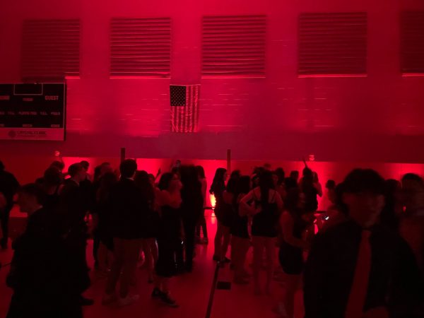 Students stand in RHS gymnasium during the winter formal. 