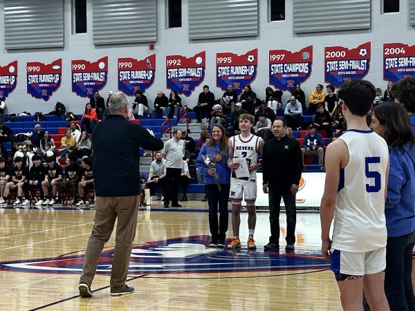 Seniors and their families walk across the court at senior night.