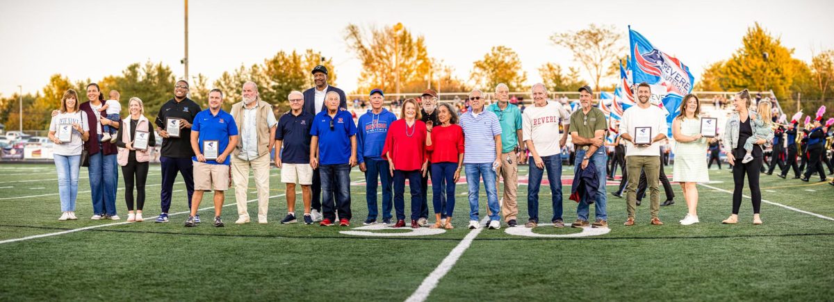 The 2025 Athletic Hall of Fame inductees stand on the football field. 