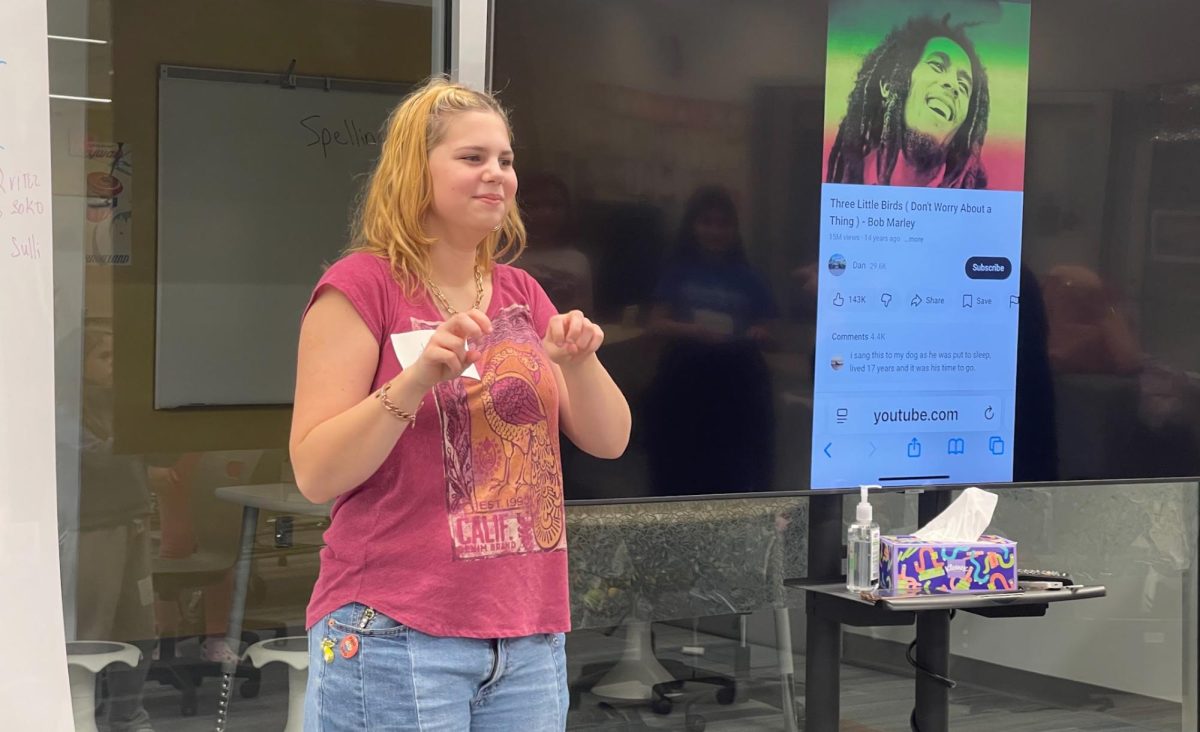 Dagny Waldron helps teach American Sign Language by signing the lyrics to a Bob Marley song.