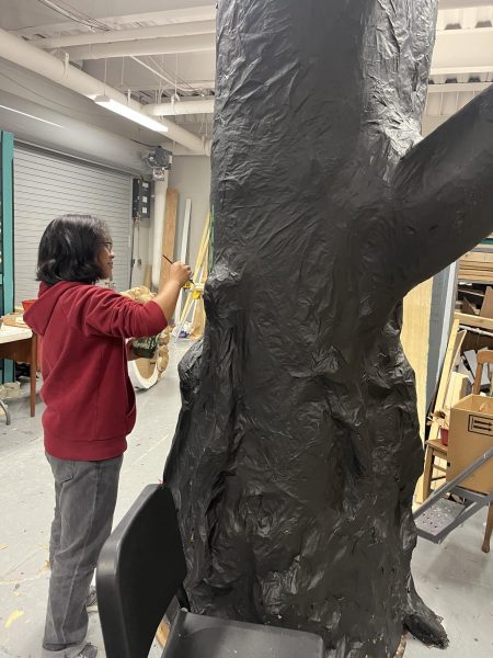 A student works on pieces for set design for the fall play.