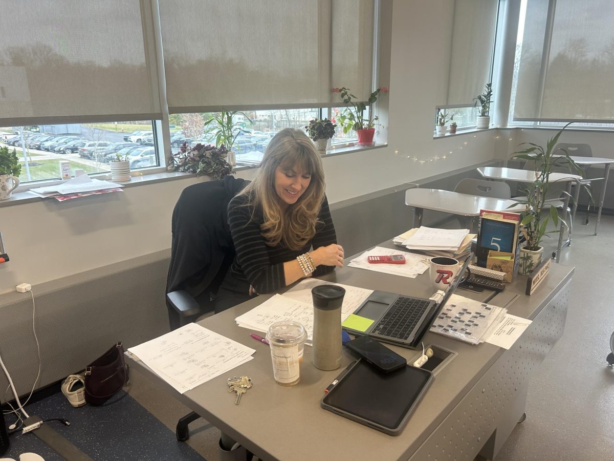 Stephanie Mason sits at her desk in her classroom while preparing for class to start.